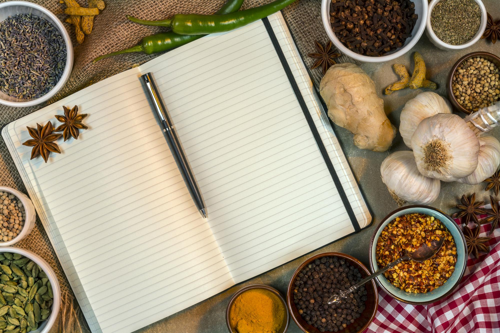 Notebooks and spice jars on a paper surface